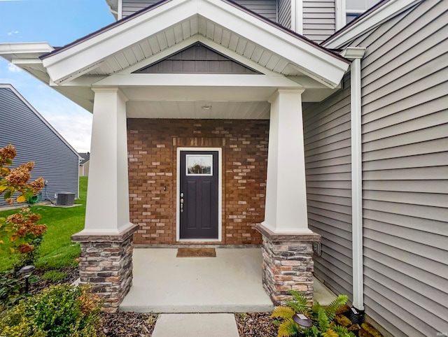 entrance to property featuring a porch and central AC unit