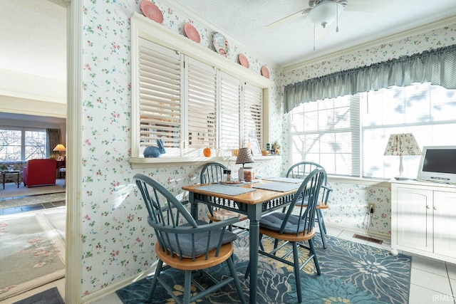 tiled dining room featuring a textured ceiling, ceiling fan, and ornamental molding