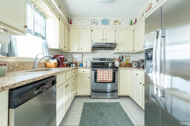 kitchen featuring sink, crown molding, cream cabinetry, stainless steel appliances, and light stone counters