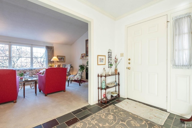 carpeted foyer featuring ornamental molding and lofted ceiling