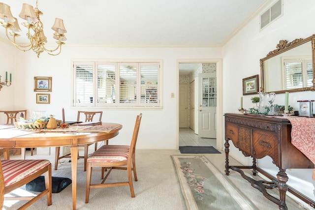 carpeted dining space with ornamental molding and an inviting chandelier