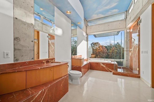 bathroom featuring vanity, a tub to relax in, tile patterned floors, and a wealth of natural light