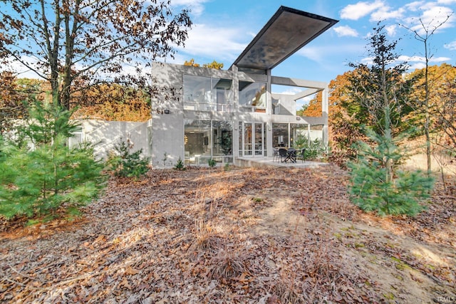 back of house with a balcony, a patio area, and a sunroom