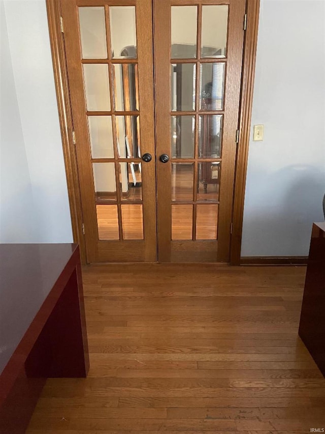 corridor featuring french doors and wood-type flooring