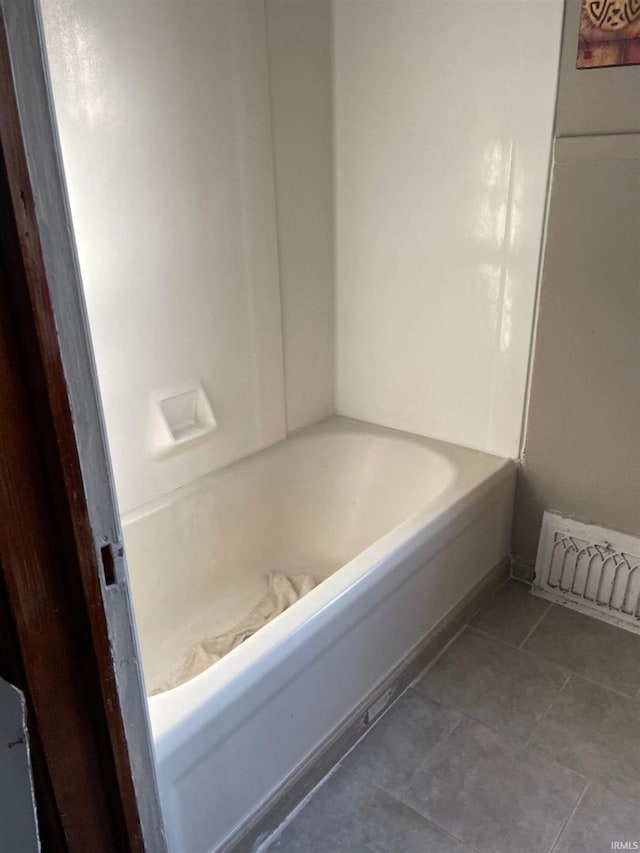 bathroom with a tub to relax in and tile patterned flooring