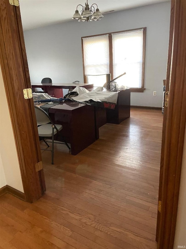 office space featuring an inviting chandelier and hardwood / wood-style flooring