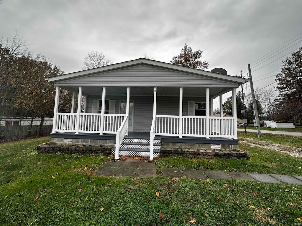 view of front of property with covered porch and a front yard