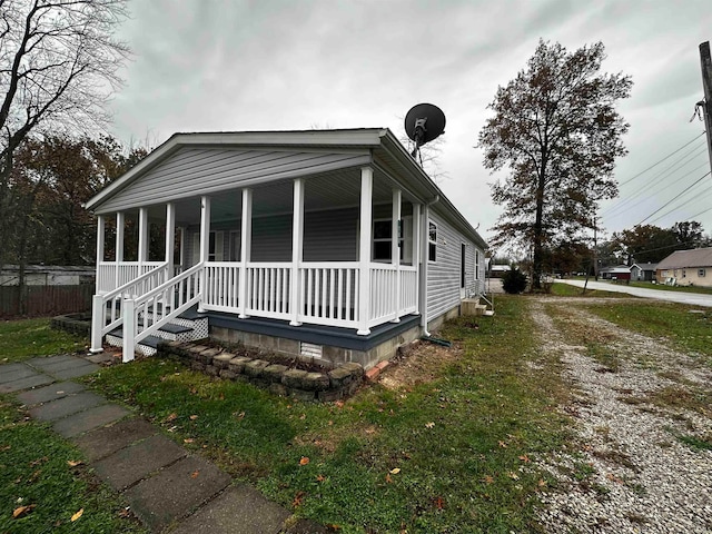 view of front of house featuring covered porch and a front yard