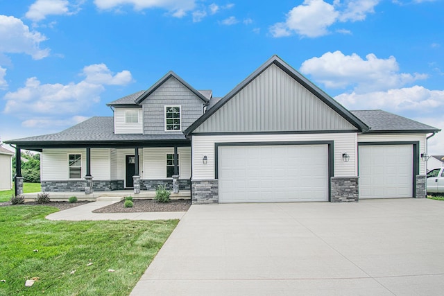 view of front facade with a front lawn, covered porch, and a garage