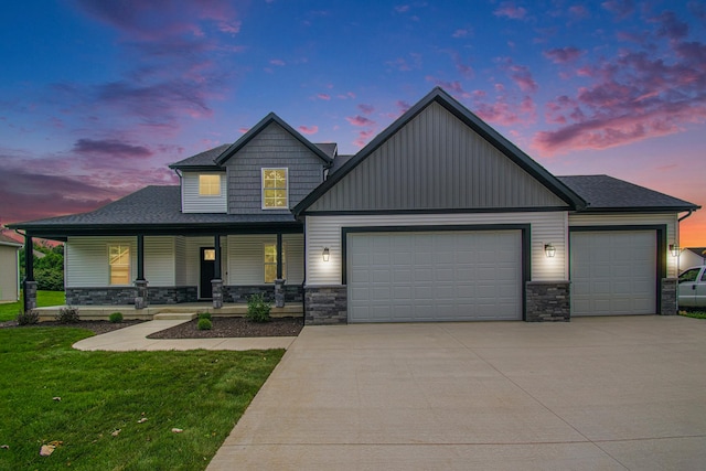 craftsman-style house featuring covered porch, a yard, and a garage