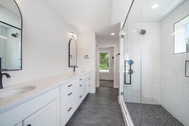 bathroom with a shower with door and vanity