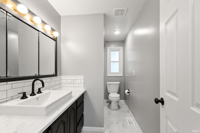 bathroom featuring decorative backsplash, vanity, and toilet