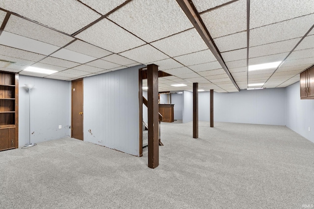 basement with light carpet and a paneled ceiling