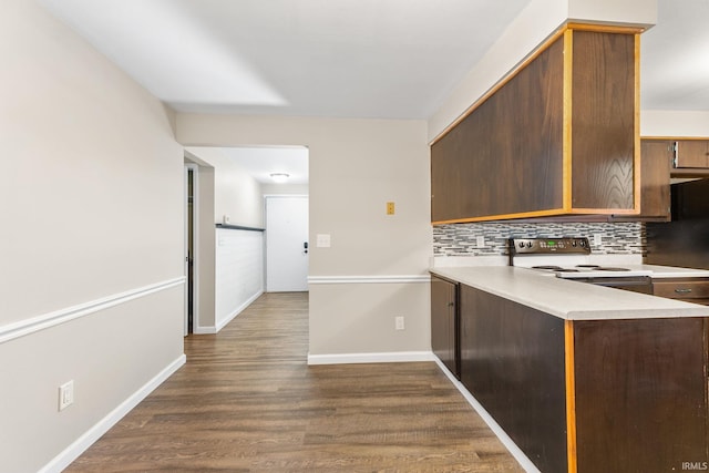 kitchen featuring tasteful backsplash, a barn door, stainless steel range with electric cooktop, and dark hardwood / wood-style floors