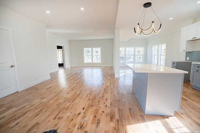 kitchen with decorative light fixtures, gray cabinetry, a notable chandelier, and light wood-type flooring