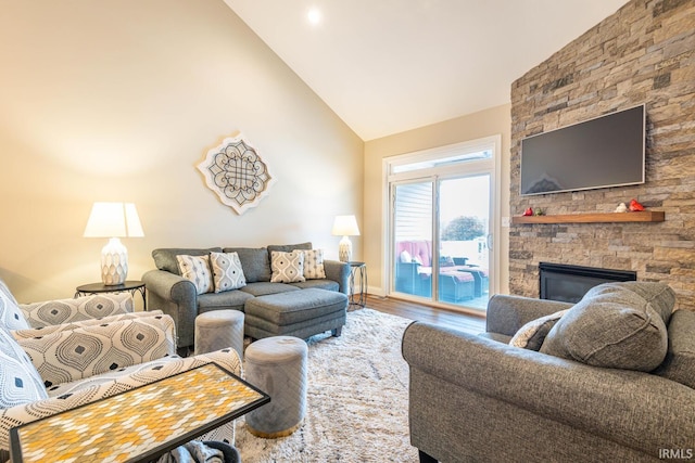 living room with a fireplace, hardwood / wood-style floors, and high vaulted ceiling