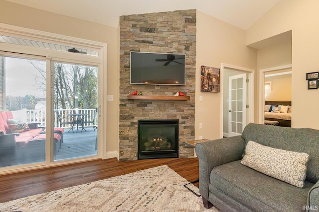 living room featuring a fireplace, vaulted ceiling, and dark wood-type flooring