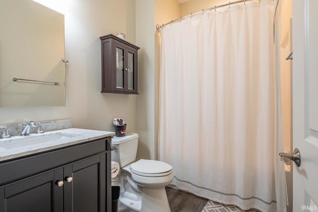 bathroom with vanity, toilet, and hardwood / wood-style flooring