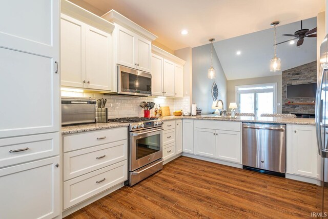 kitchen with white cabinets, sink, vaulted ceiling, dark wood-type flooring, and stainless steel appliances