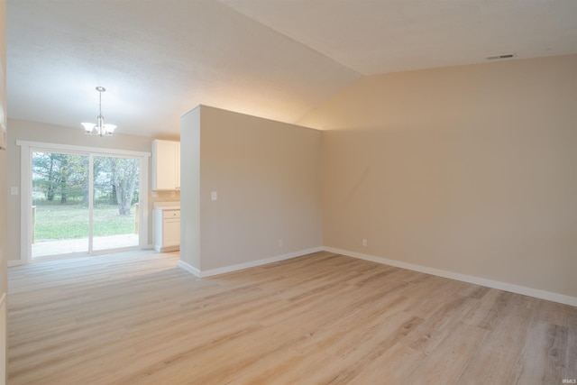 unfurnished room featuring a notable chandelier, lofted ceiling, and light hardwood / wood-style floors