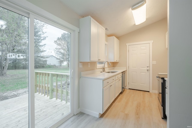 kitchen featuring range with electric cooktop, vaulted ceiling, sink, white cabinets, and light hardwood / wood-style floors