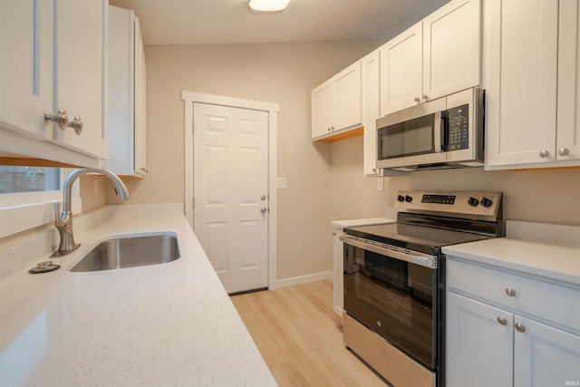 kitchen featuring white cabinets, sink, lofted ceiling, and stainless steel appliances