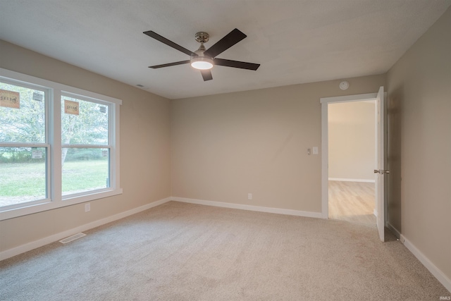 empty room featuring ceiling fan and light colored carpet