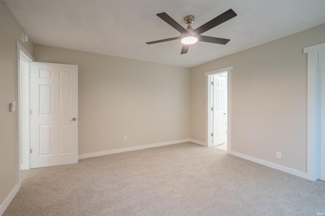 unfurnished room featuring ceiling fan and light colored carpet