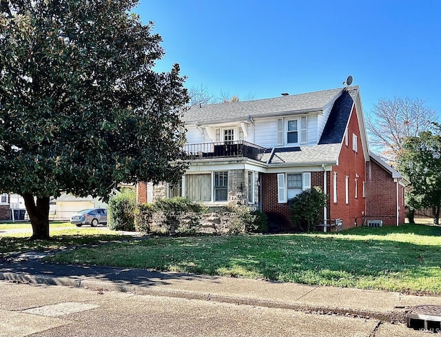 view of front of house with a balcony and a front yard