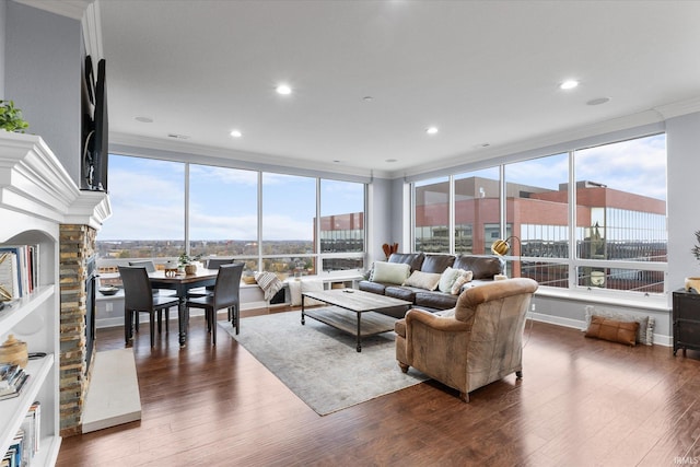 living room featuring dark hardwood / wood-style floors, a healthy amount of sunlight, and ornamental molding