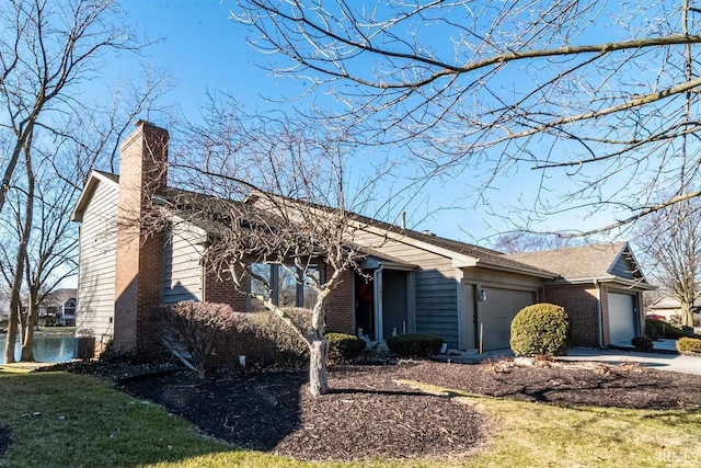 2521 Kingston Pt, Fort Wayne, IN 46815 - view of front of property with a garage, brick siding, a chimney, and concrete driveway