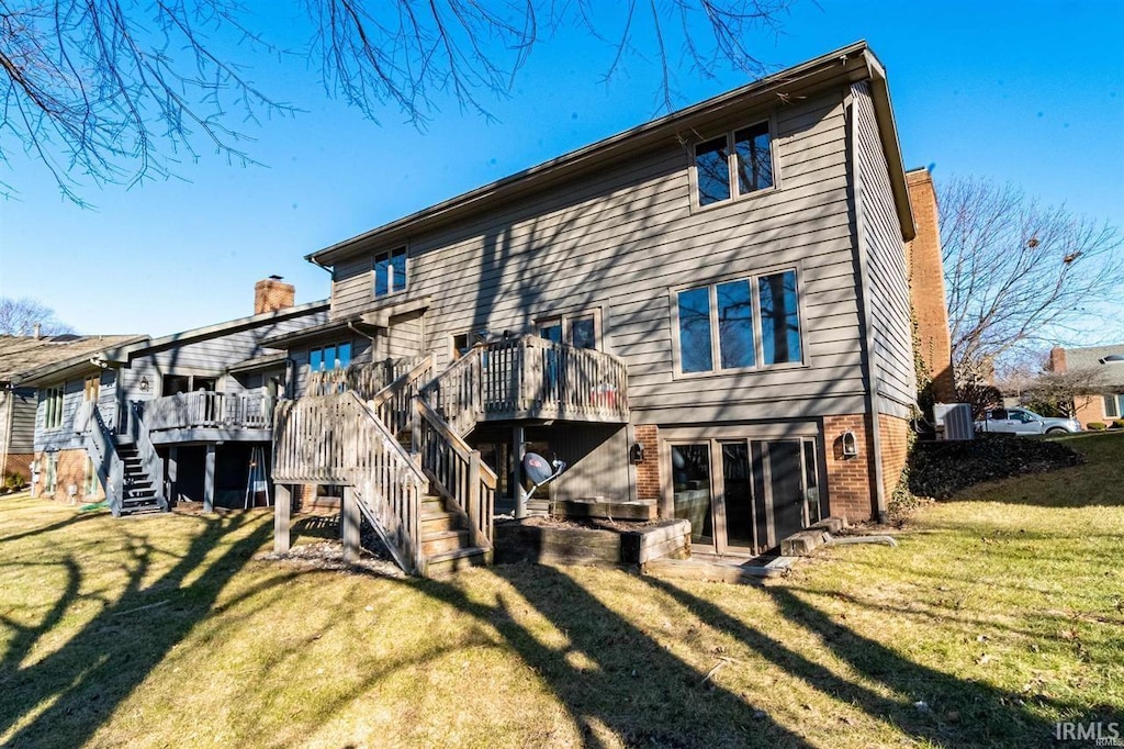 rear view of property featuring a lawn and a wooden deck