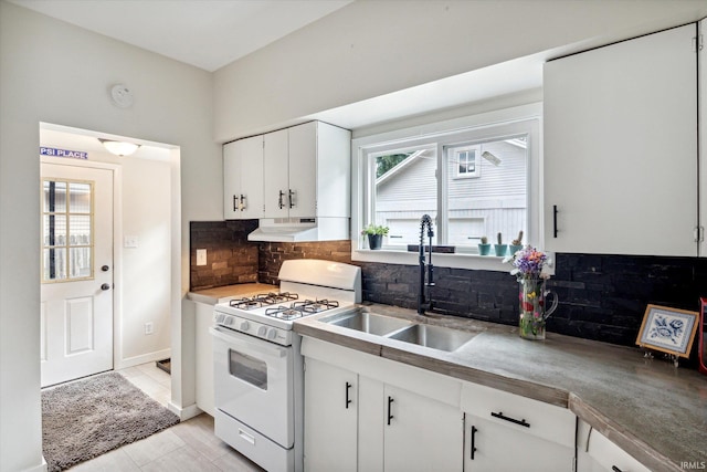 kitchen featuring white cabinetry, sink, a healthy amount of sunlight, and white gas range oven