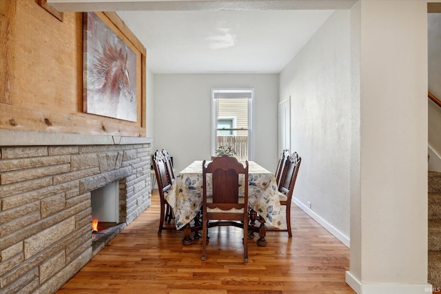 dining area with wood-type flooring and a fireplace