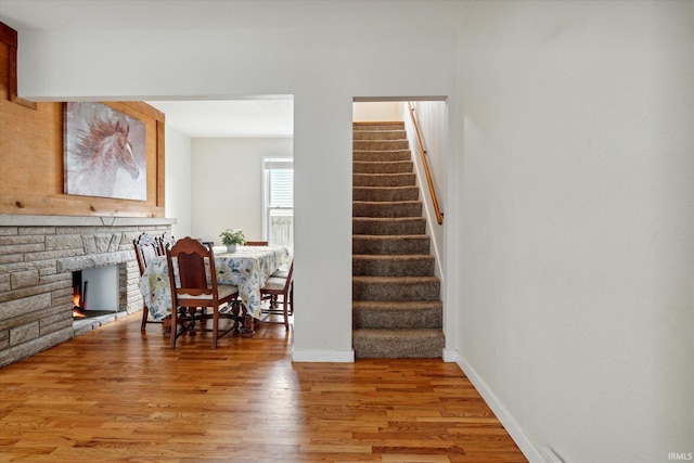 staircase with a fireplace and wood-type flooring