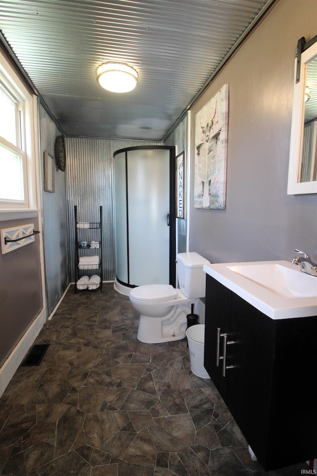 bathroom featuring vanity, toilet, and an enclosed shower