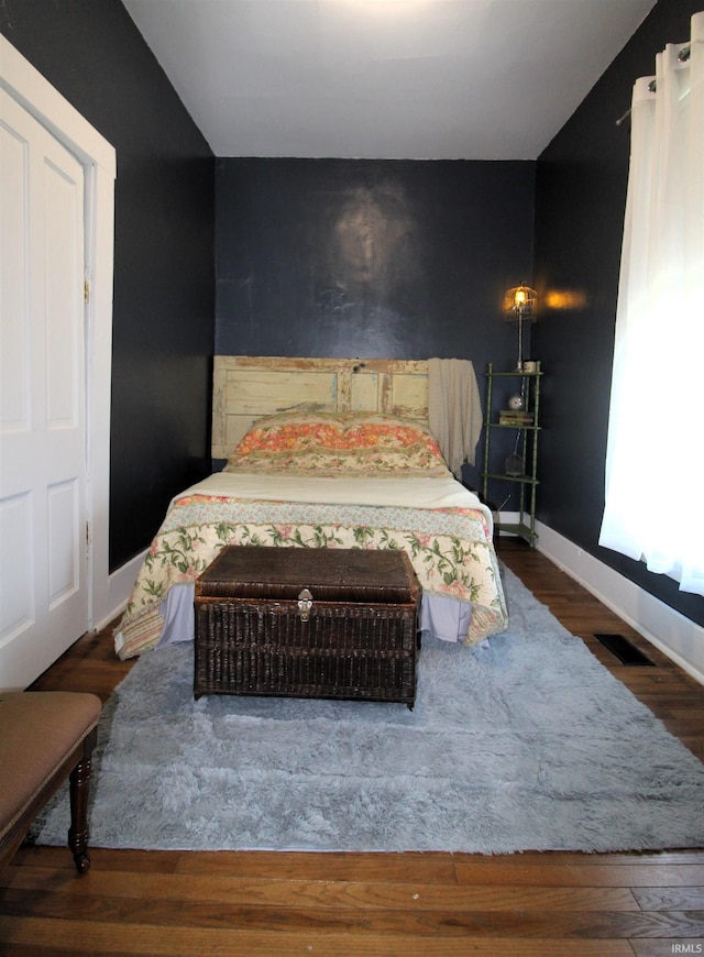 bedroom with dark hardwood / wood-style floors