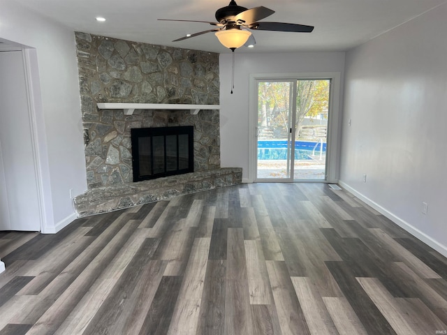 unfurnished living room featuring a fireplace, ceiling fan, and dark wood-type flooring