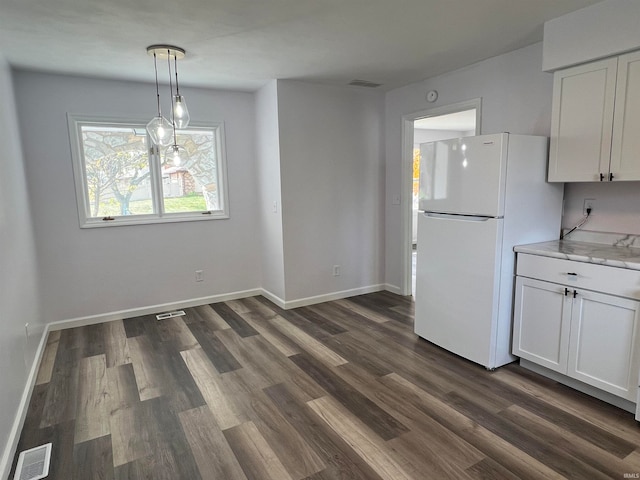 unfurnished dining area featuring dark wood-type flooring