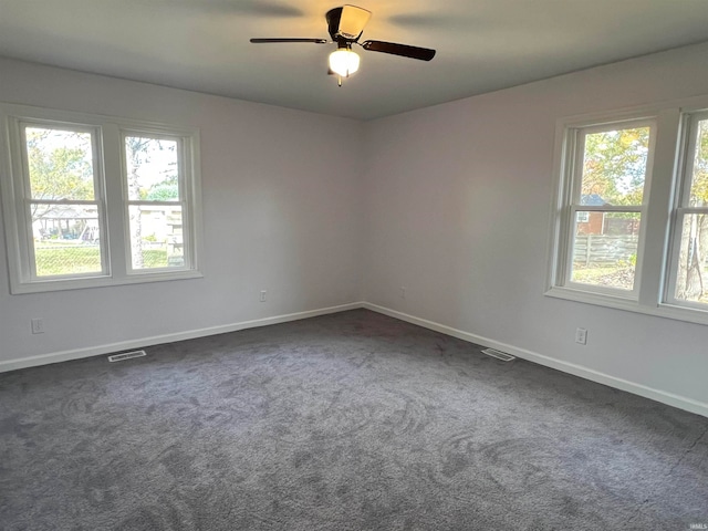 spare room with ceiling fan and dark carpet