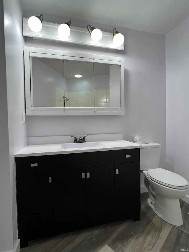 bathroom with hardwood / wood-style floors, vanity, and toilet