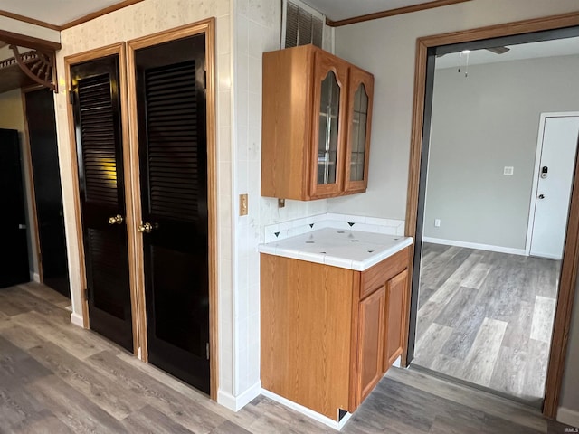 bathroom with hardwood / wood-style floors and ornamental molding