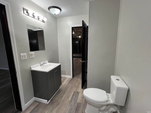 bathroom featuring vanity, wood-type flooring, and toilet