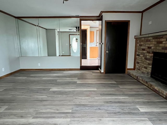 unfurnished living room featuring a fireplace, ceiling fan, light hardwood / wood-style flooring, and ornamental molding