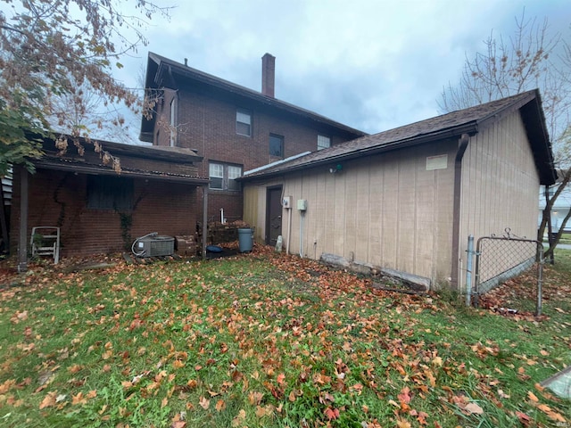 back of property featuring a lawn and central AC unit