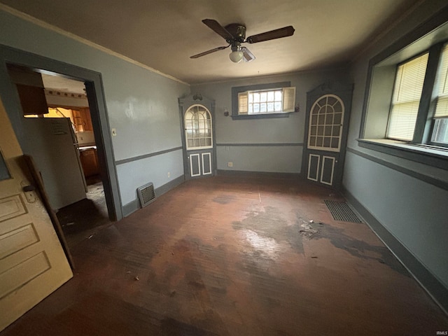 unfurnished room with ceiling fan and ornamental molding