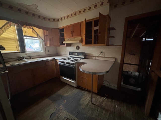 kitchen with kitchen peninsula, white gas range oven, tasteful backsplash, sink, and fridge