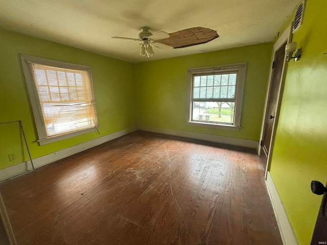 empty room with ceiling fan and dark wood-type flooring