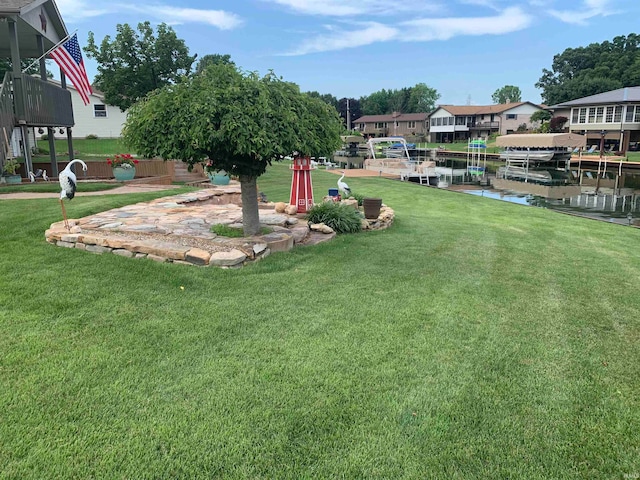 view of yard with a boat dock and a water view