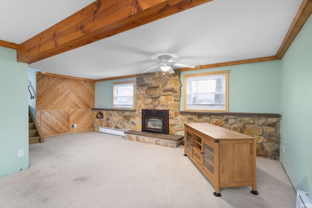 living room with plenty of natural light, a wood stove, light carpet, and baseboard heating